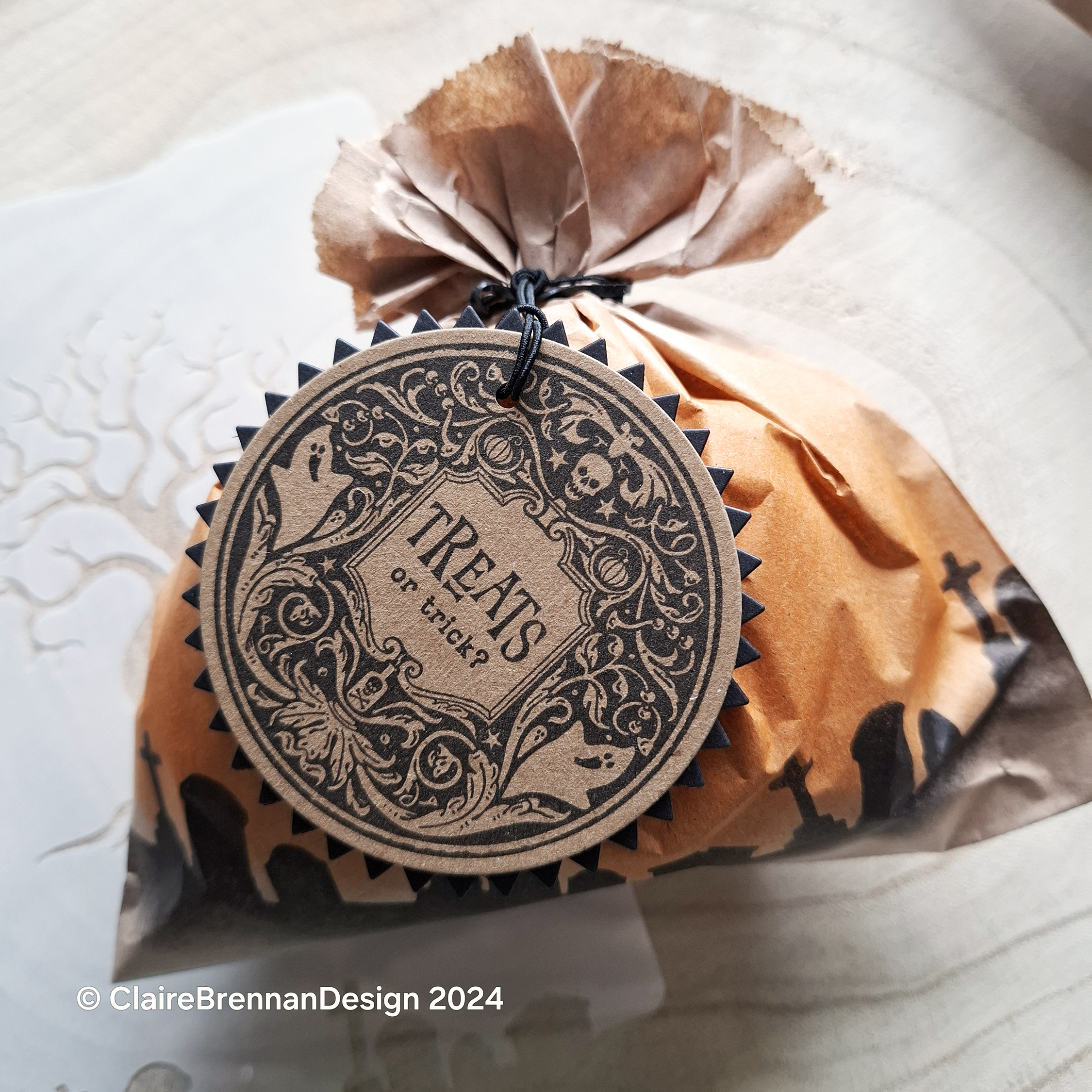 small brown paper bag filled with sweets and tied at the top, with a handmade gift tag in black and kraft card.