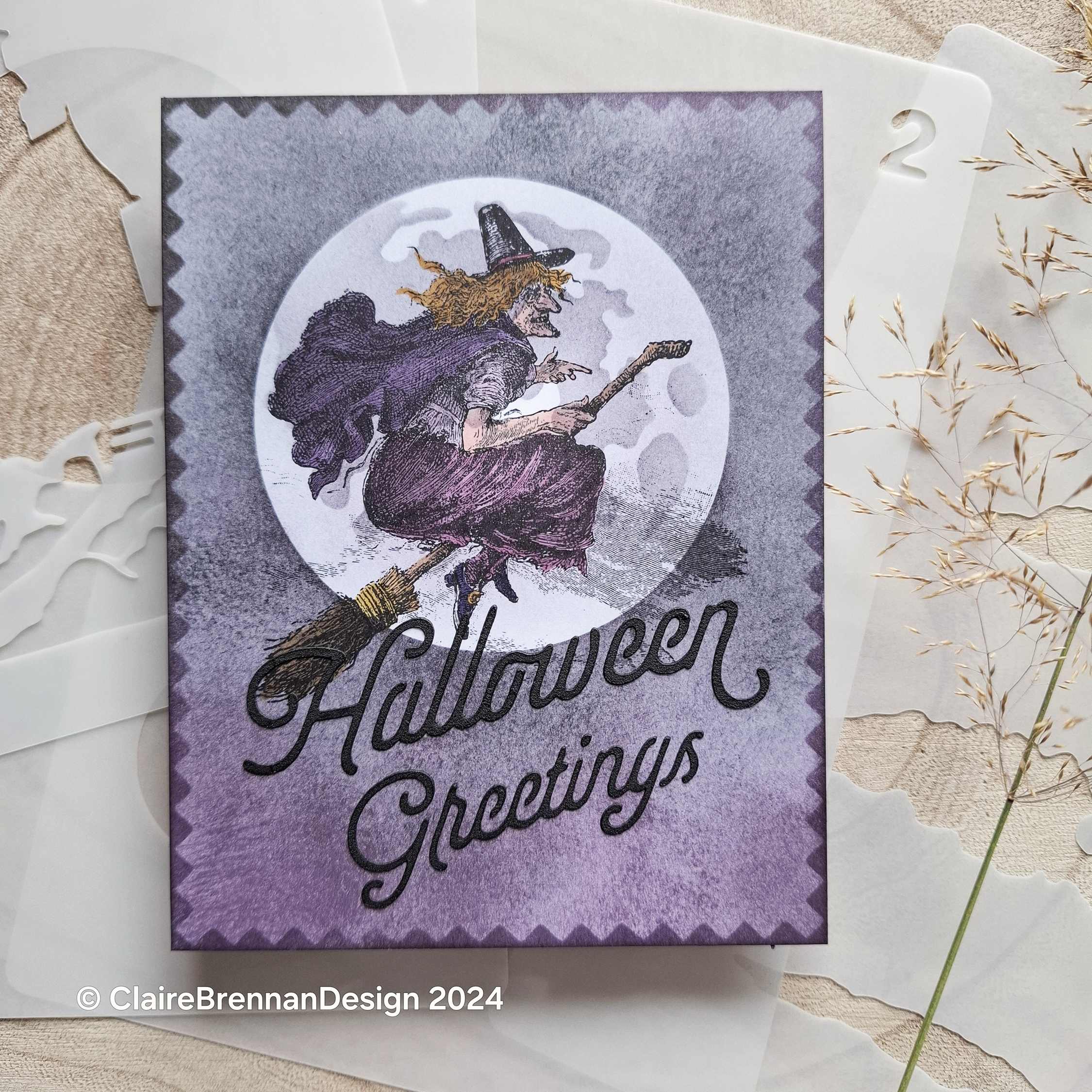 grey and plum coloured greeting card featuring a Victorian engraving of witch on a broomstick, in front of a pale grey moon